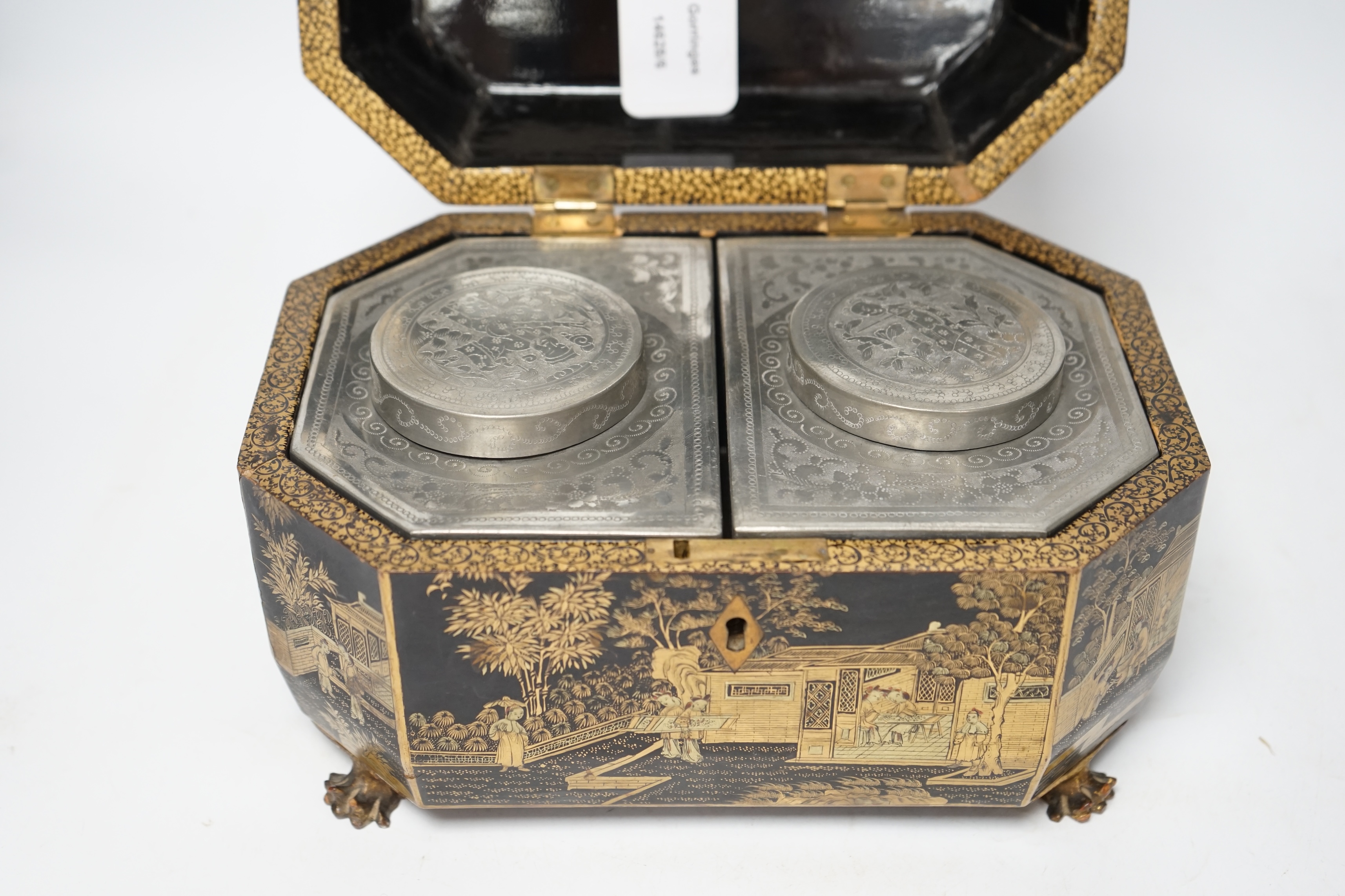 A mid 19th century Chinese export black and gold lacquer tea caddy, retaining engraved pewter tea canisters, raised on paw feet, 26cm wide. Condition - poor